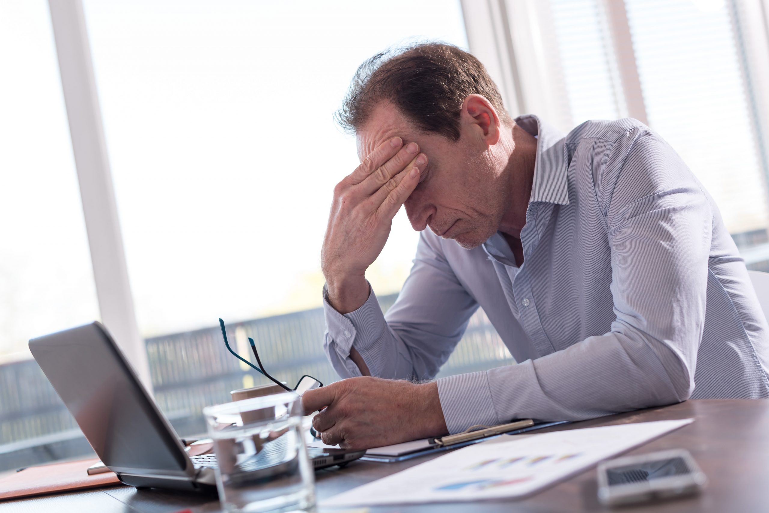 exhausted man staring at laptop